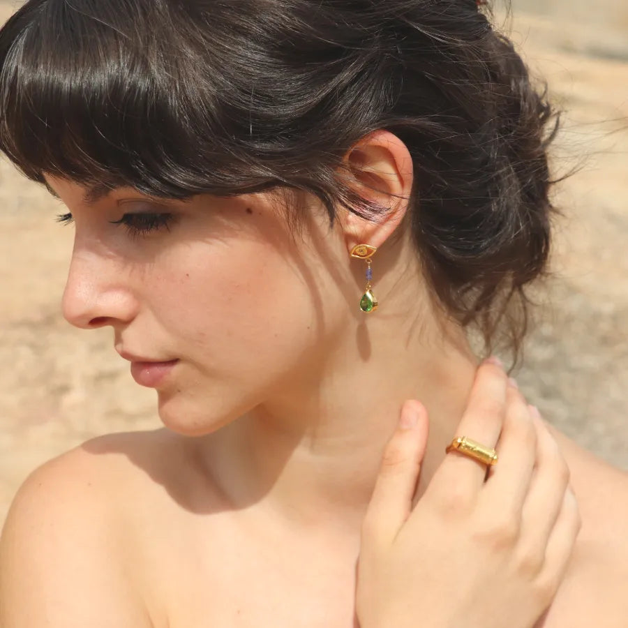 Gold-plated All-Seeing Eyes Earrings with tanzanite beads and pear shaped green crystal drops worn on a model