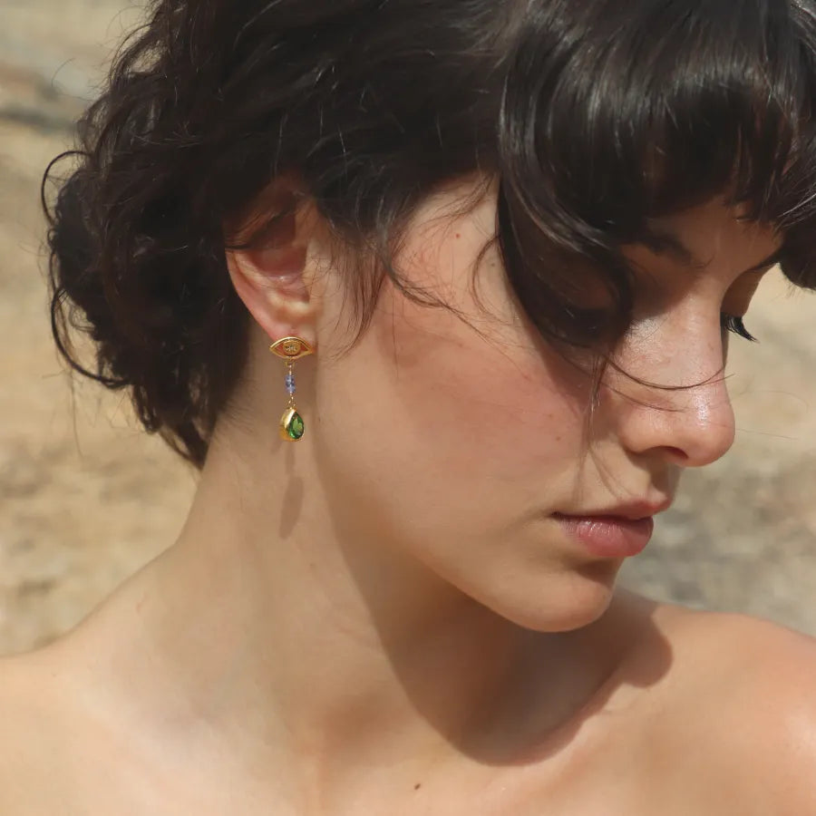 Gold-plated All-Seeing Eyes Earrings with tanzanite beads and pear shaped green crystal drops styled on a model