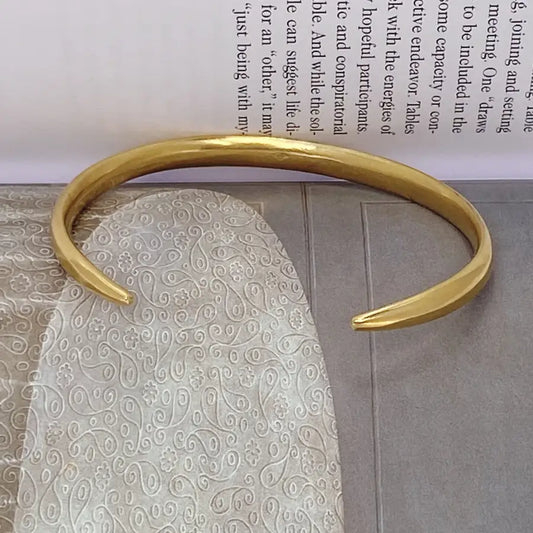 Handcrafted gold-plated open bracelet shown from the side