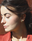 Woman wearing a gold-plated cabochon stud with an ear cuff, handmade by Izaskun Zabala.