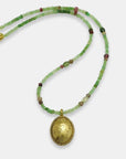 Green and pink gemstone beads necklace with a gold-plated oval engraved medallion, handmade by Izaskun Zabala.
