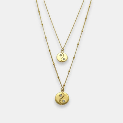 Two gold-plated yin yang pendants with sapphires necklaces, handmade by Izaskun Zabala.