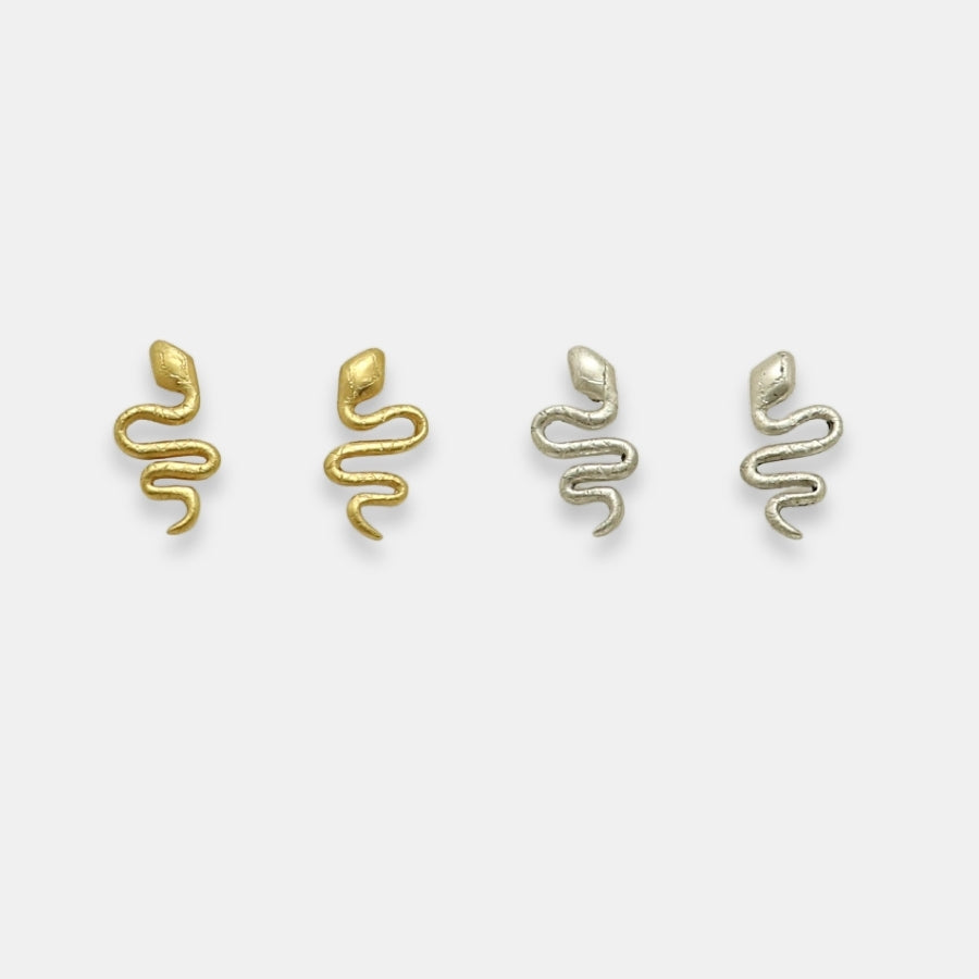 Two pairs of snake-shaped earrings, one gold-plated and one silver, handcrafted by Izaskun Zabala.