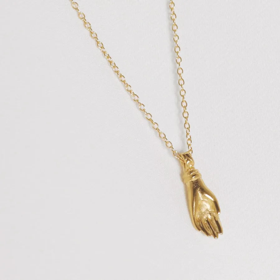 Back of gold-plated miniature hand pendant necklace, handmade by Izaskun Zabala.