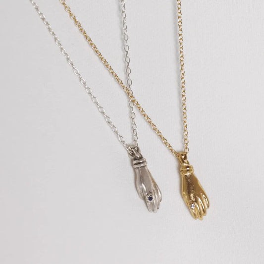 Set of silver and gold-plated miniature hand pendant necklaces with stone ring, handmade by Izaskun Zabala.