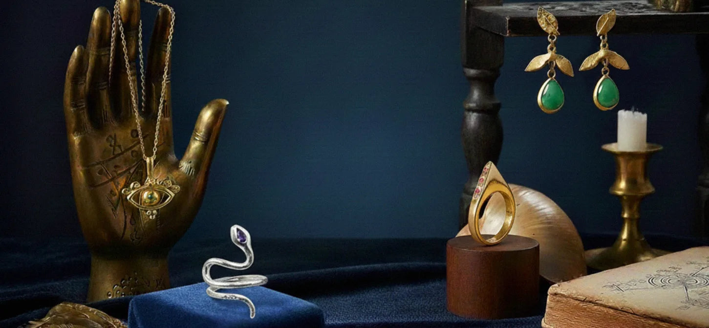 Dark blue still life with palmistry hand and artisan silver and gold-plated jewelry by Izaskun Zabala.