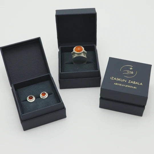 Handmade silver jewelry set in dark blue boxes with 'Izaskun Zabala Artisan Jewelry' branding.