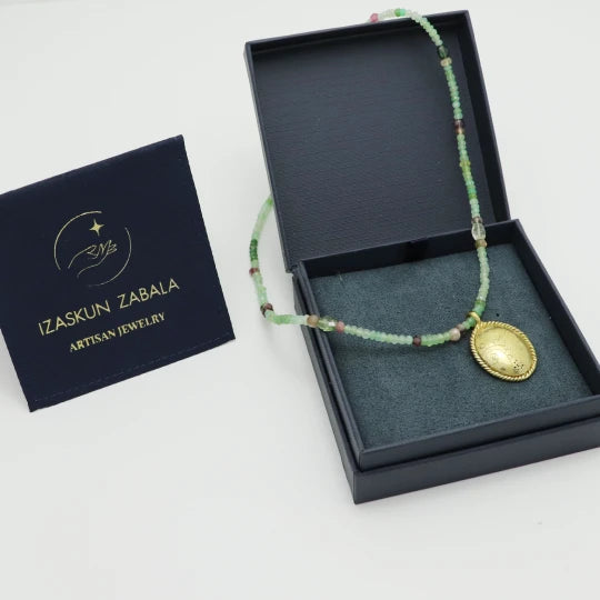 Beaded necklace with a gold-plated pendant in an Izaskun Zabala branded box.