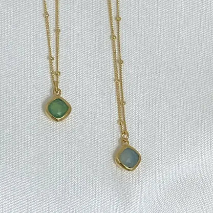 Image is a set of gold filled chain necklaces with a cushion cut gemstone pendant, handmade by Izaskun Zabala.