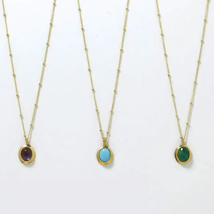 Three gold-plated oval cabochon pendant necklaces, handmade by Izaskun Zabala.