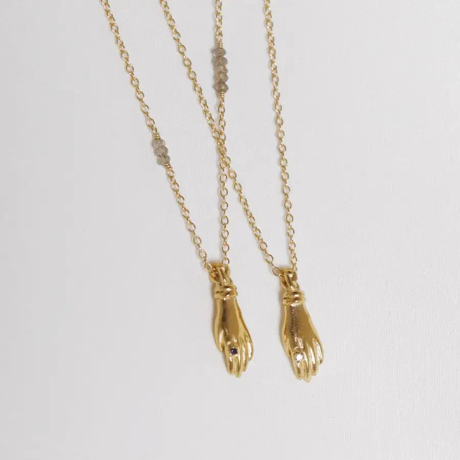 Set of gold-plated miniature hand pendant necklaces with stone ring, handmade by Izaskun Zabala.