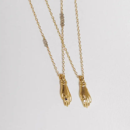 Set of gold-plated miniature hand pendant necklaces with stone ring, handmade by Izaskun Zabala.