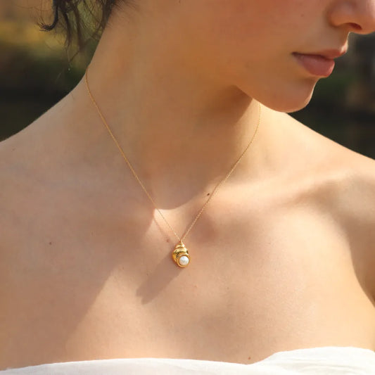 Shell-inspired gold-plated Nerea Necklace featuring a button pearl styled on a model