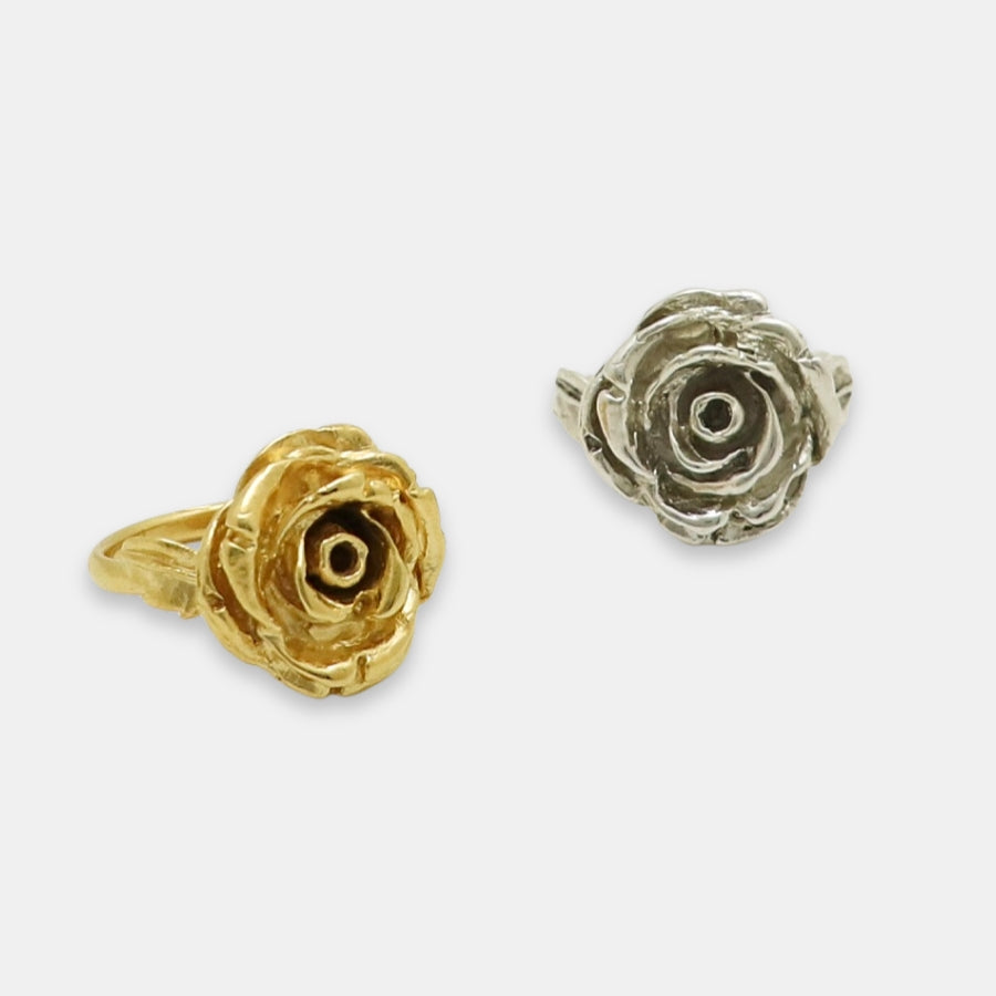 Gold and silver rose-shaped rings on a white background