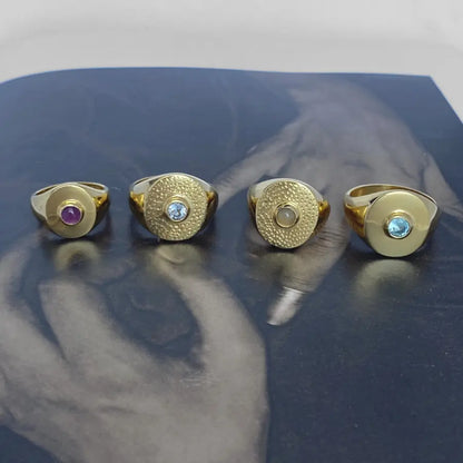 Modern gold-plated signet rings featuring a bezel-set gemstone