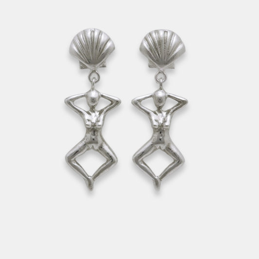 Pair of silver earrings with shell-like tops and female figure dangles, handmade by Izaskun Zabala.