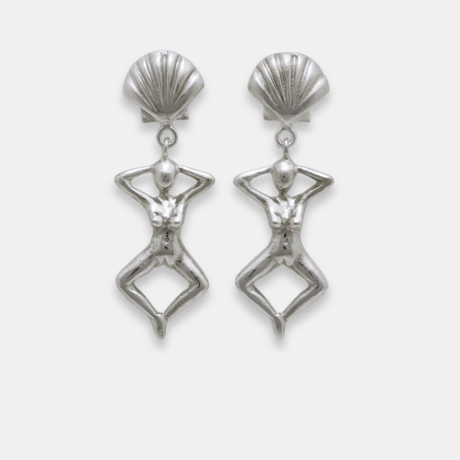 Pair of silver earrings with shell-like tops and female figure dangles, handmade by Izaskun Zabala.