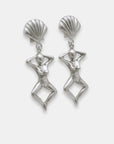 Side view of silver earrings with shell-like tops and female figure dangles, handmade by Izaskun Zabala.