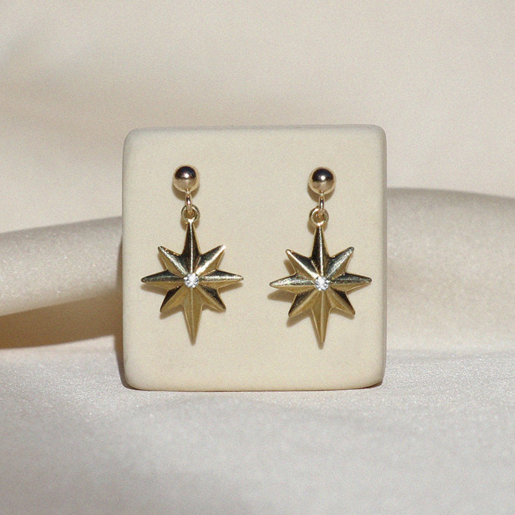 Izaskun Zabala Jewelry delicate star dangle earrings with a white sapphire on a ball stud