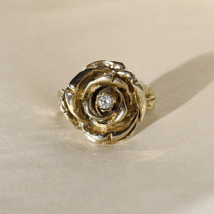 Image is a hand carved statement rose ring in brass with a three millimetre white cubic zirconia as center stone